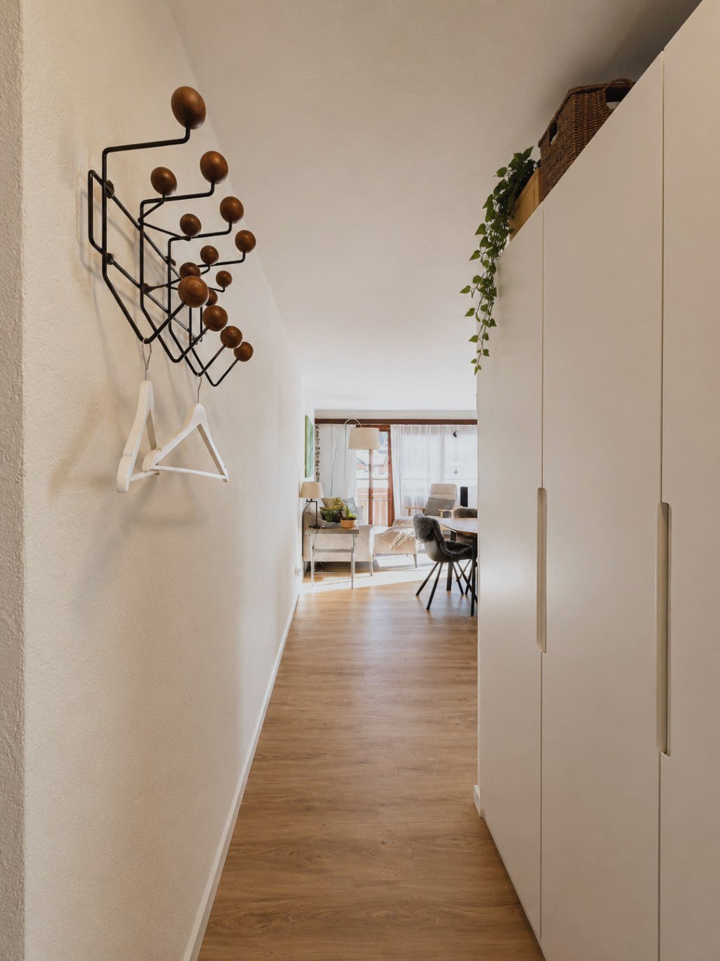 Entrée d'Auri avec portemanteau en bois et métal et vue sur le séjour