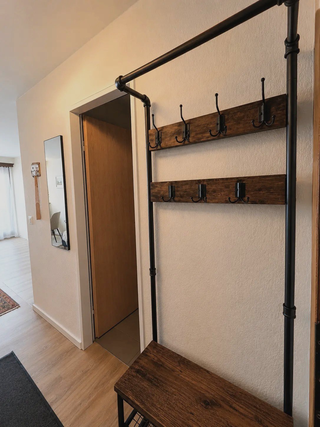 Entrance of the Malo studio with wood and black metal coat rack