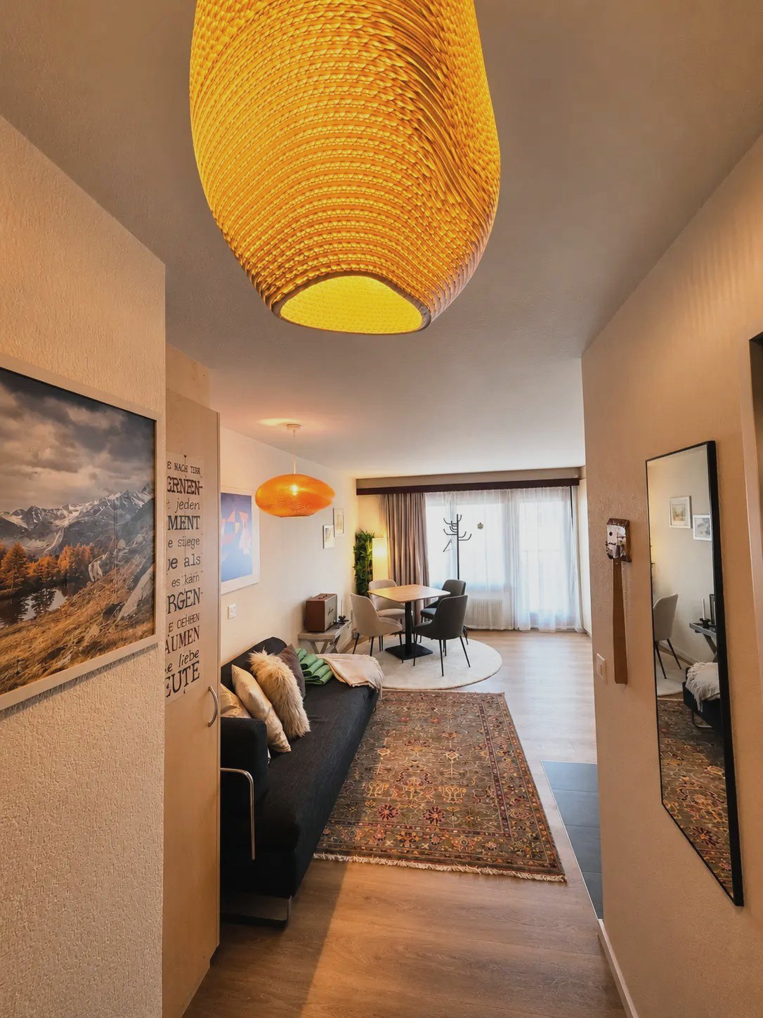 View from the entrance through the Malo studio: sofa, dining table and windows