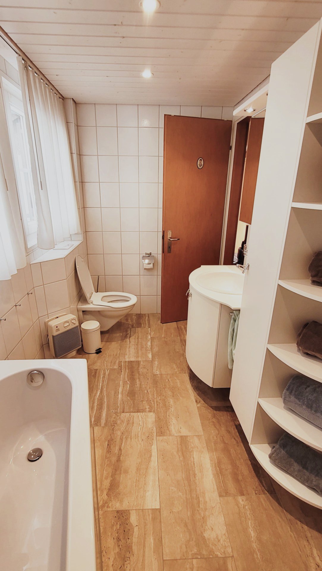 Helles Badezimmer im Chalet Nördli mit Badewanne und warmem Holzboden