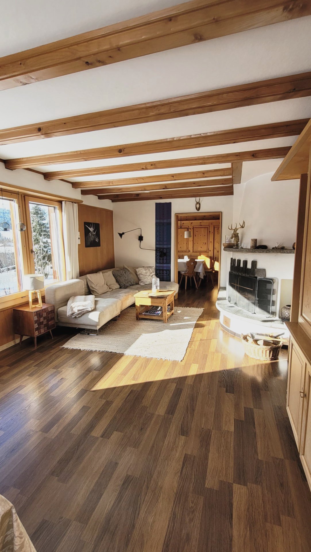 Wohnraum im Chalet Nördli mit Kamin, Sofa und Blick in die Essecke